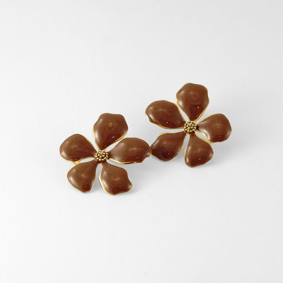 Fleurs à cinq pétales en émail brun glossy, cerclées d’or. Une touche seventies très actuelle.