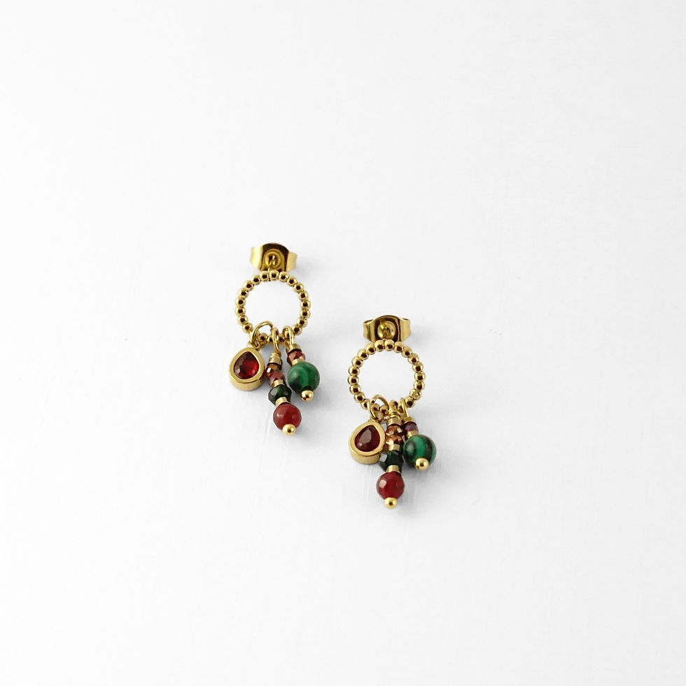 Créoles perlées de petites pampilles rouges et vertes façon talismans modernes : un accent coloré qui réveille la tenue.