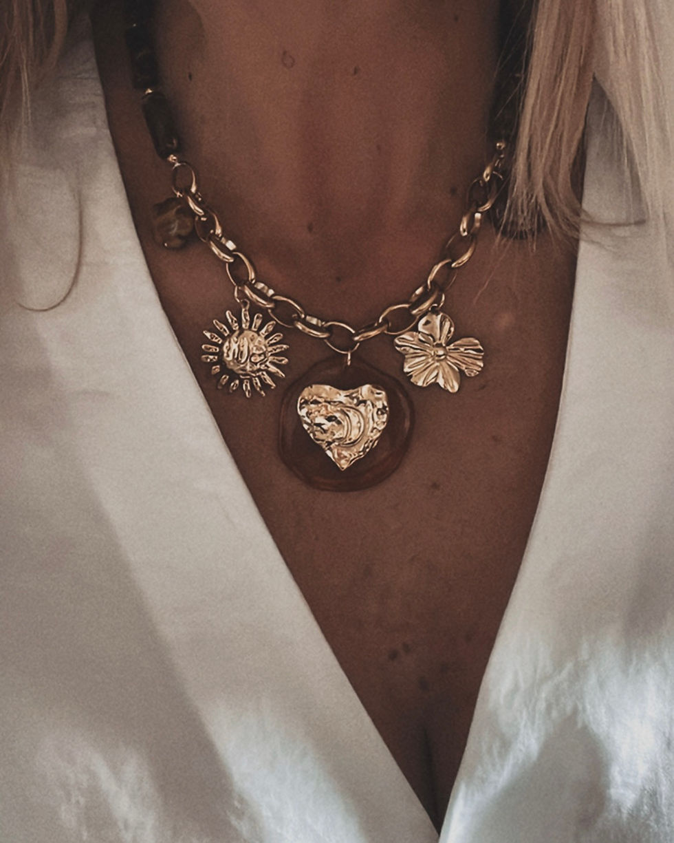 Collier médaillons dorés et pierres brunes – David  Élégance et chaleur 🌞 Ce collier associe des pendentifs dorés (soleil, f
