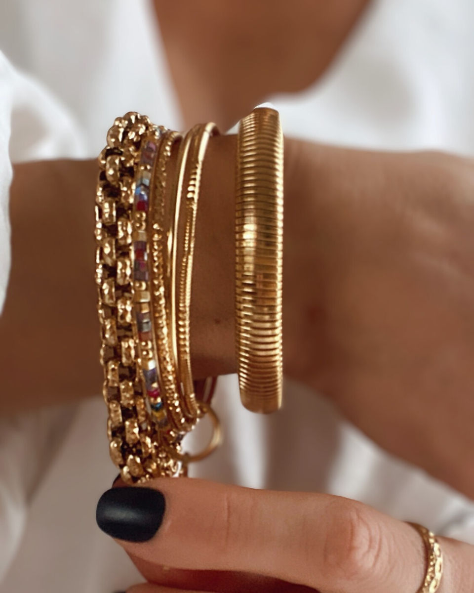 Sélection de bracelets dorés en acier inoxydable porté sur une poignée