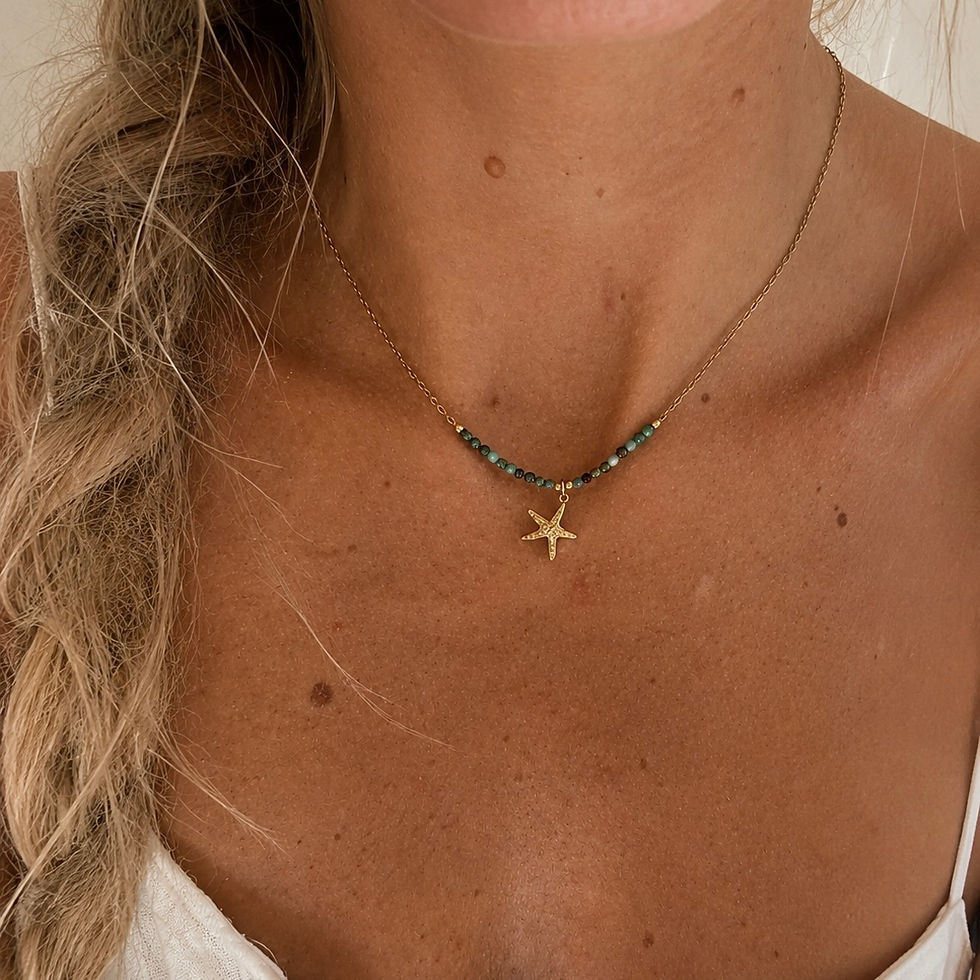 Un collier doré, orné de pierres vertes et d’un pendentif étoile de mer. Une pièce fraîche, lumineuse et parfaite pour les lo