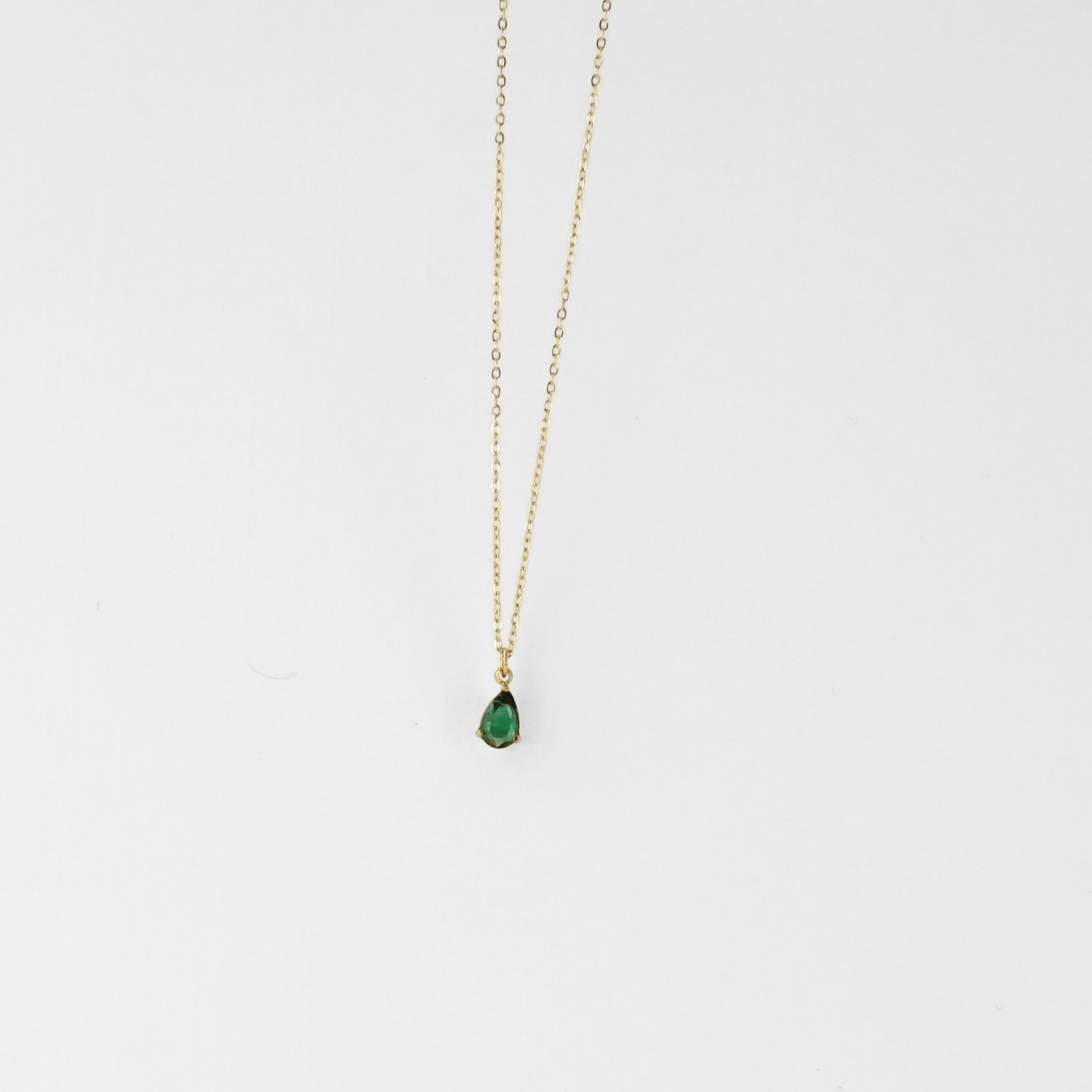 Ce collier met en valeur une goutte verte éclatante, délicatement sertie sur une chaîne fine dorée. Une touche colorée et élé