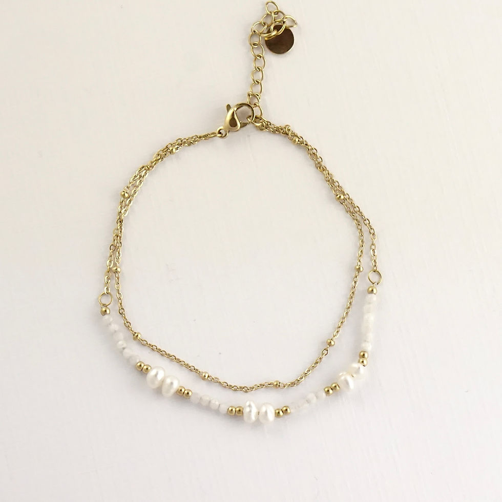 Bracelet composé de 2 chaînes. L'une simple avec des petites billes dorées et l'autre décorée de perles d'eau douce et de nac