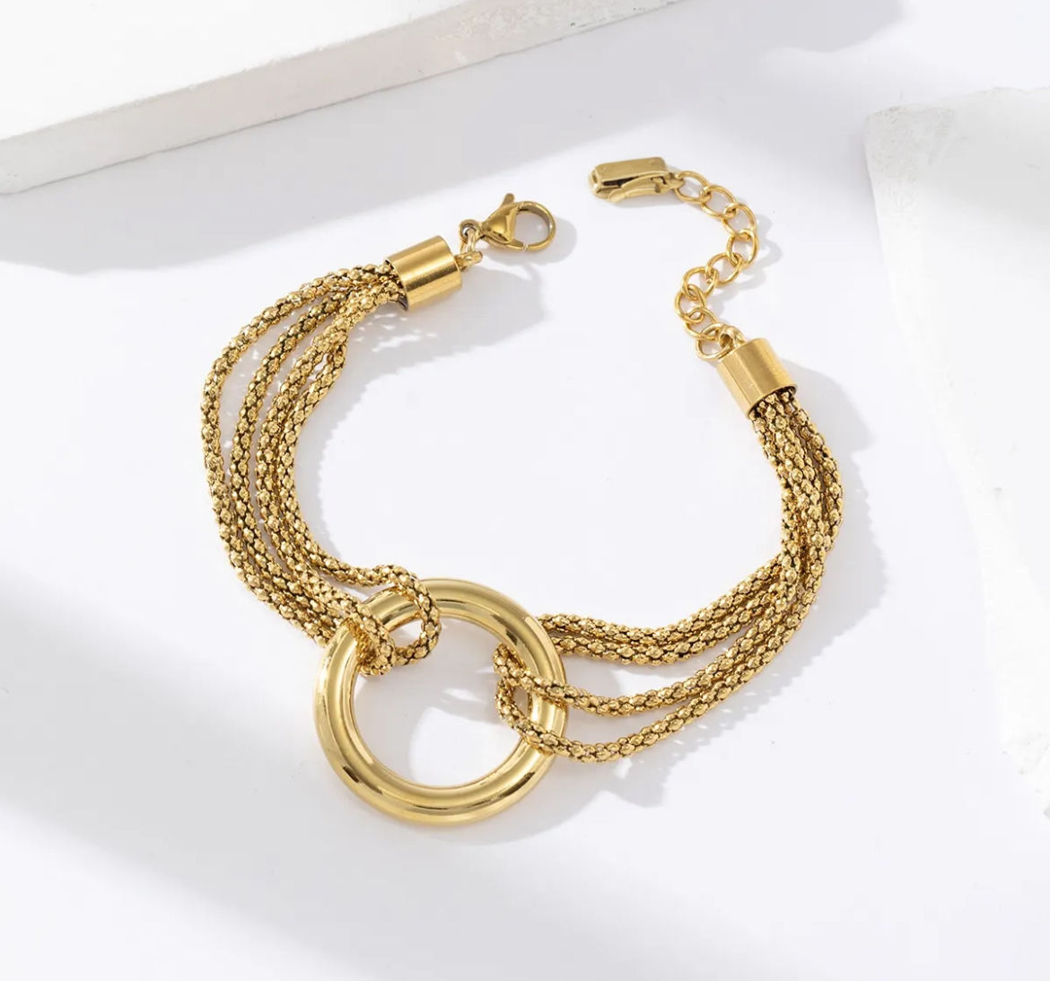 Bracelet multi chaine reliées par un anneau doré.