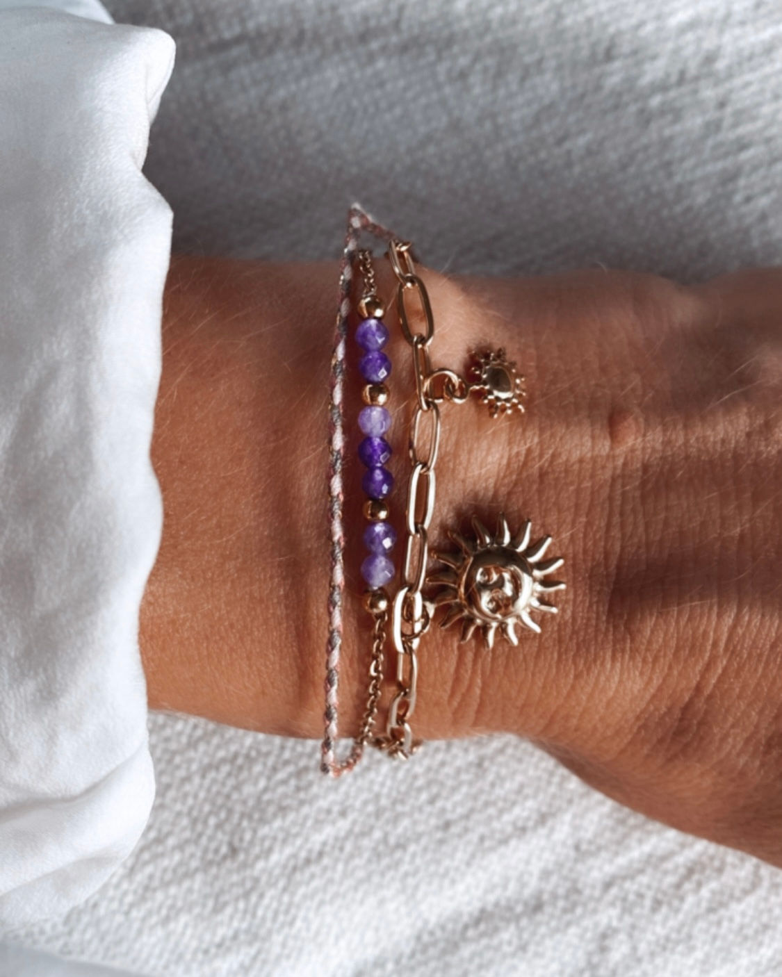 Bracelet composé de 3 rangs. Un coloré (couleur au choix Violet ou Rose) décorés de perles, un cordon tressé coloré assorti l