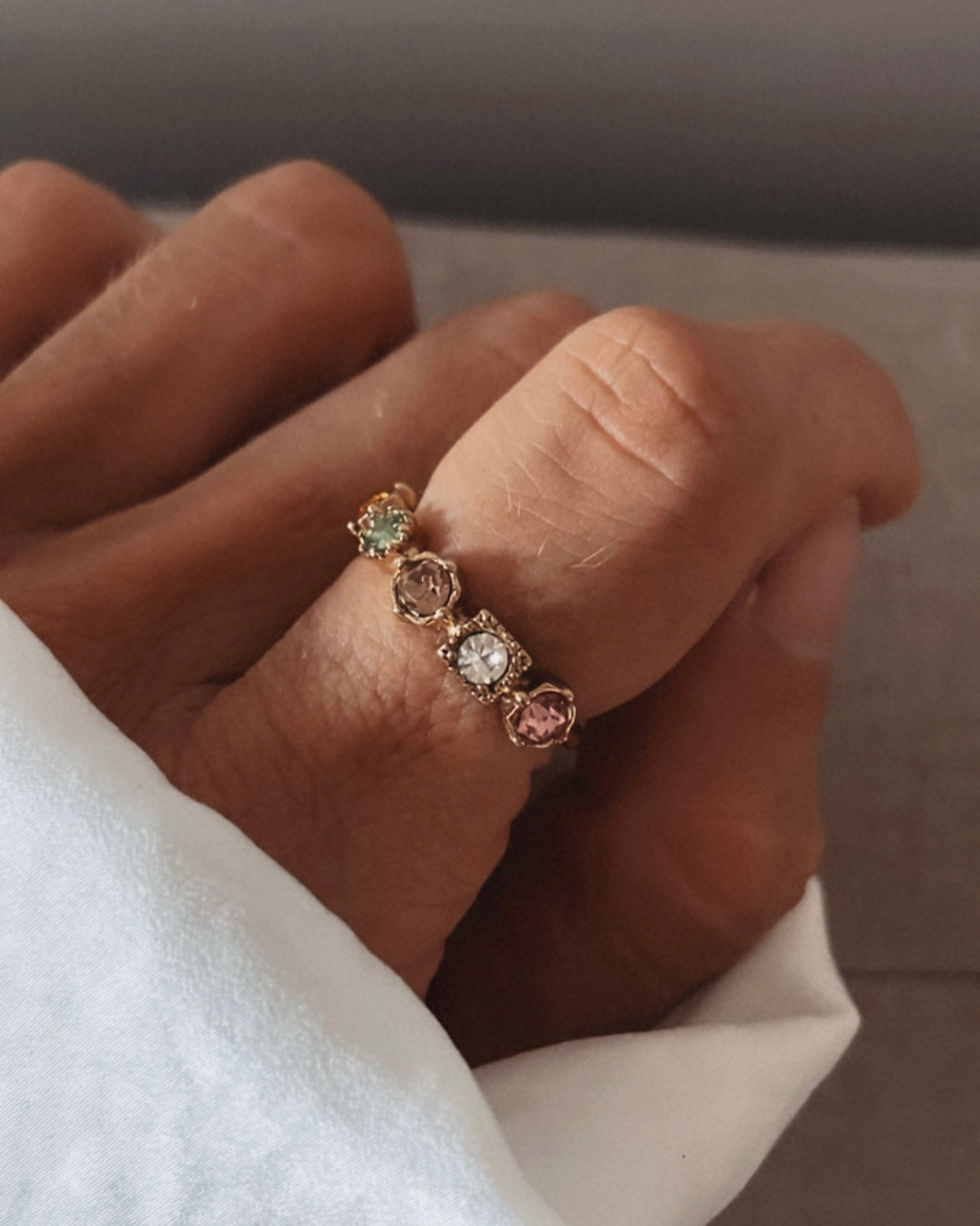 Bague anneau décorée de plusieurs pierres multi colores et de forme multiples.