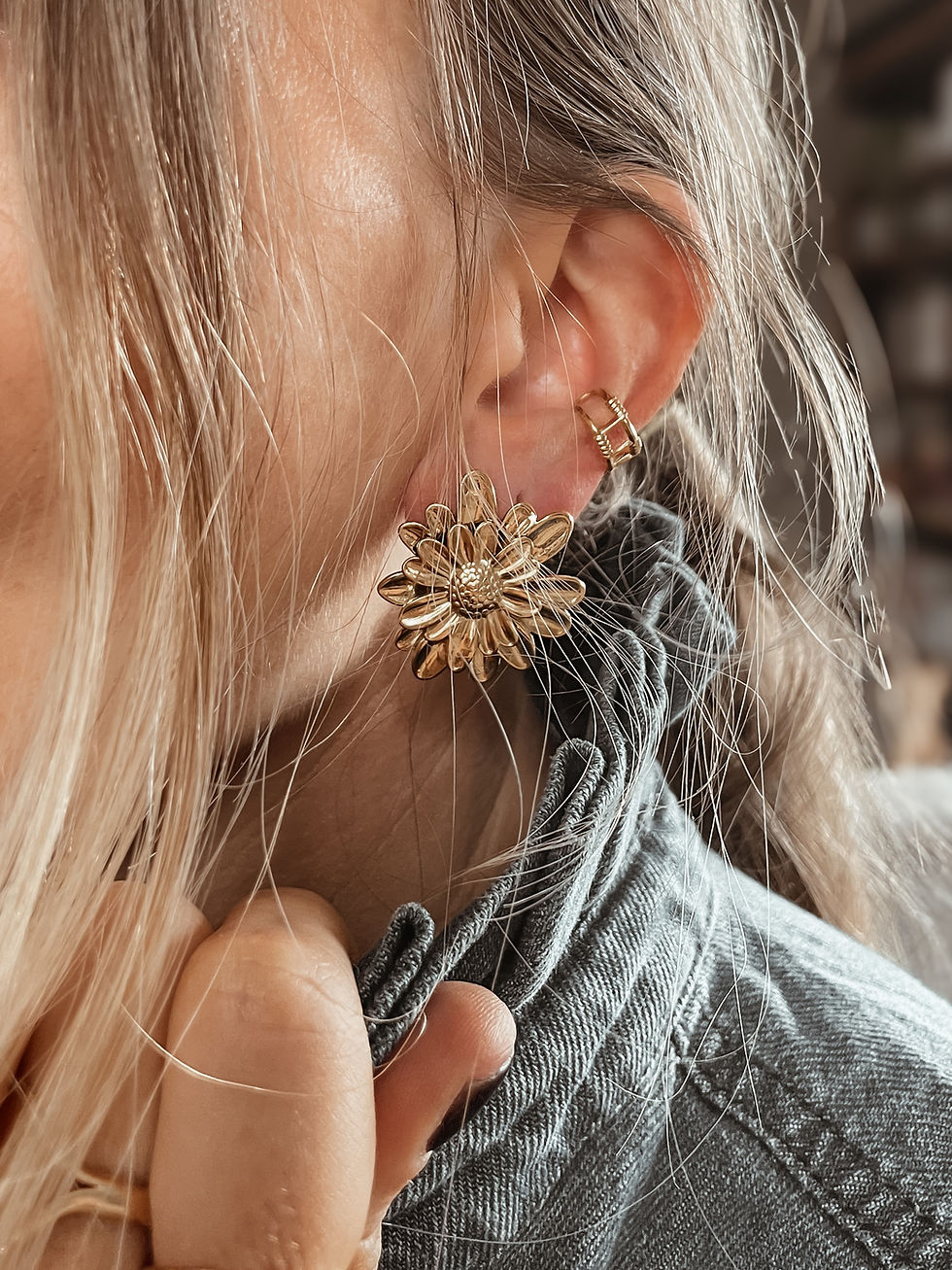 Puces en forme de marguerite en relief, pétales superposés pour un volume délicat. Le bijou “bonne humeur” qui réveille une t
