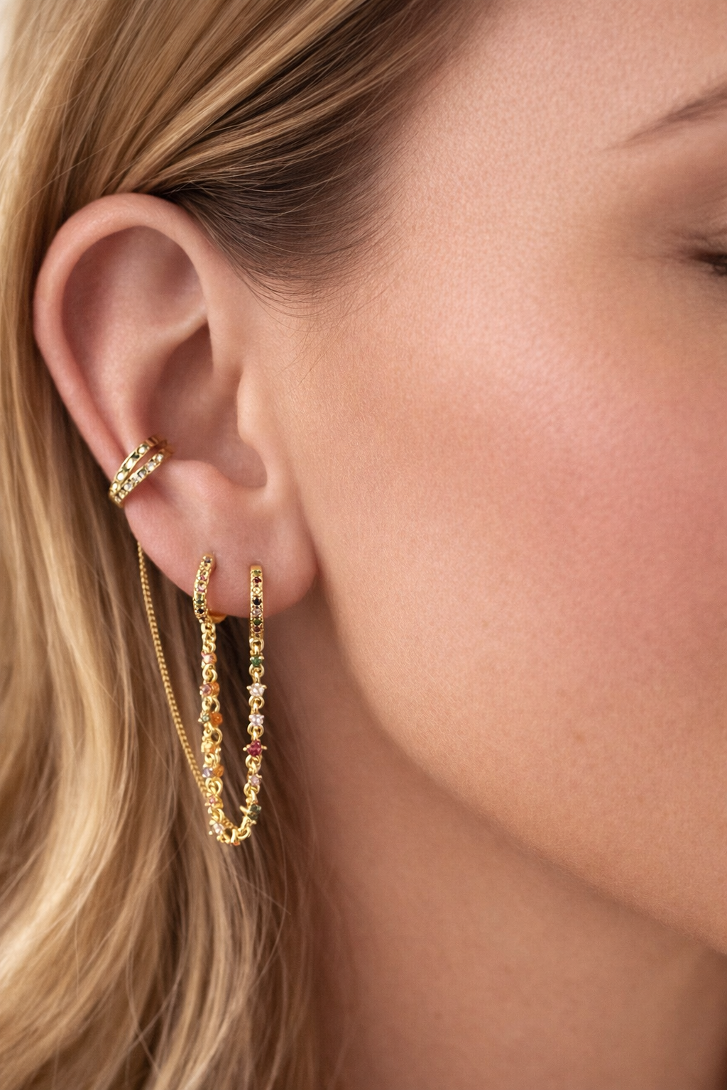 Bijou d’oreille original composé de deux mini créoles reliées par une fine chaîne ornée de petites pierres multicolores