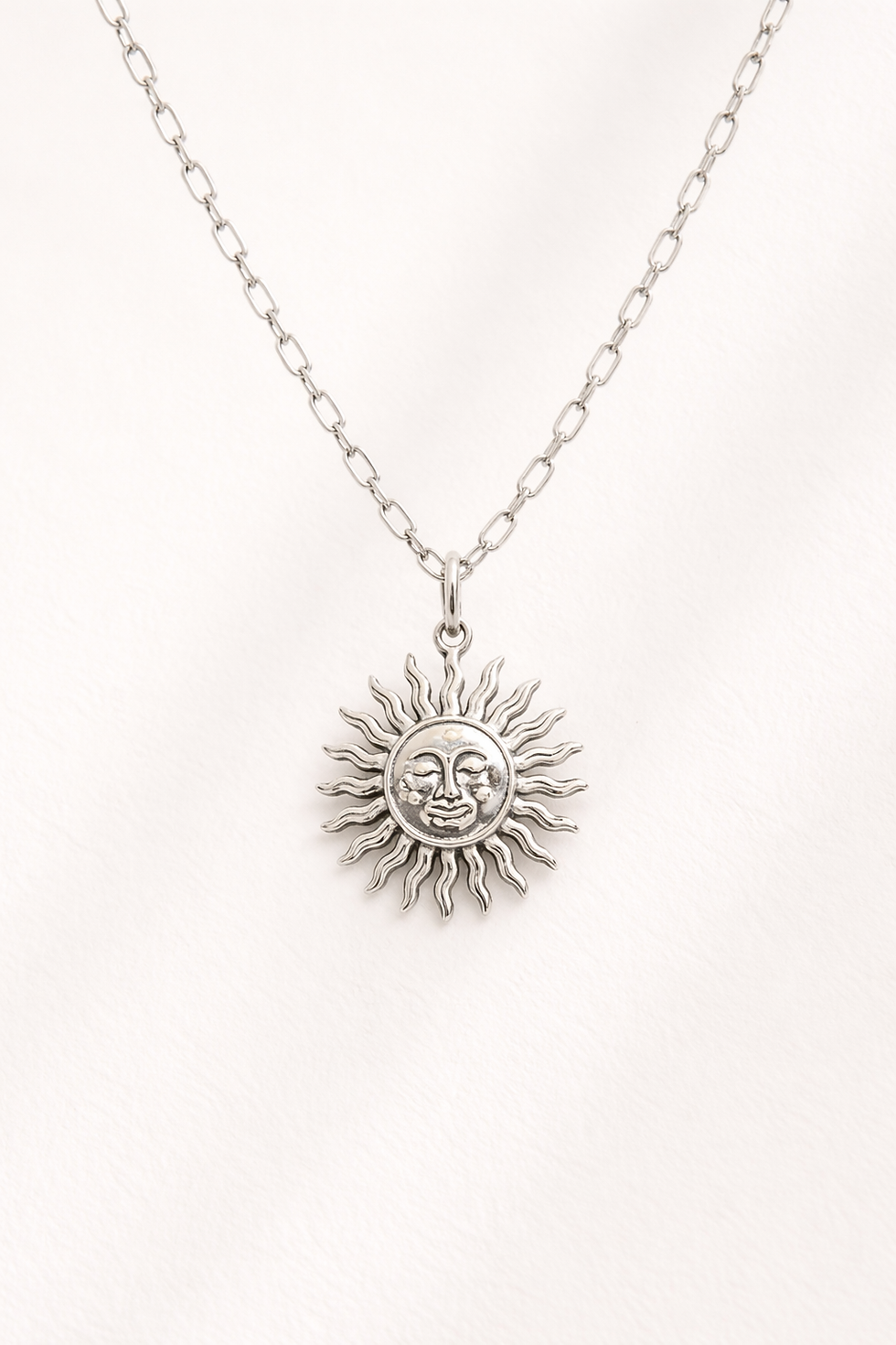 pendentif soleil au visage délicatement sculpté, à la fois lumineux, bohème et intemporel.