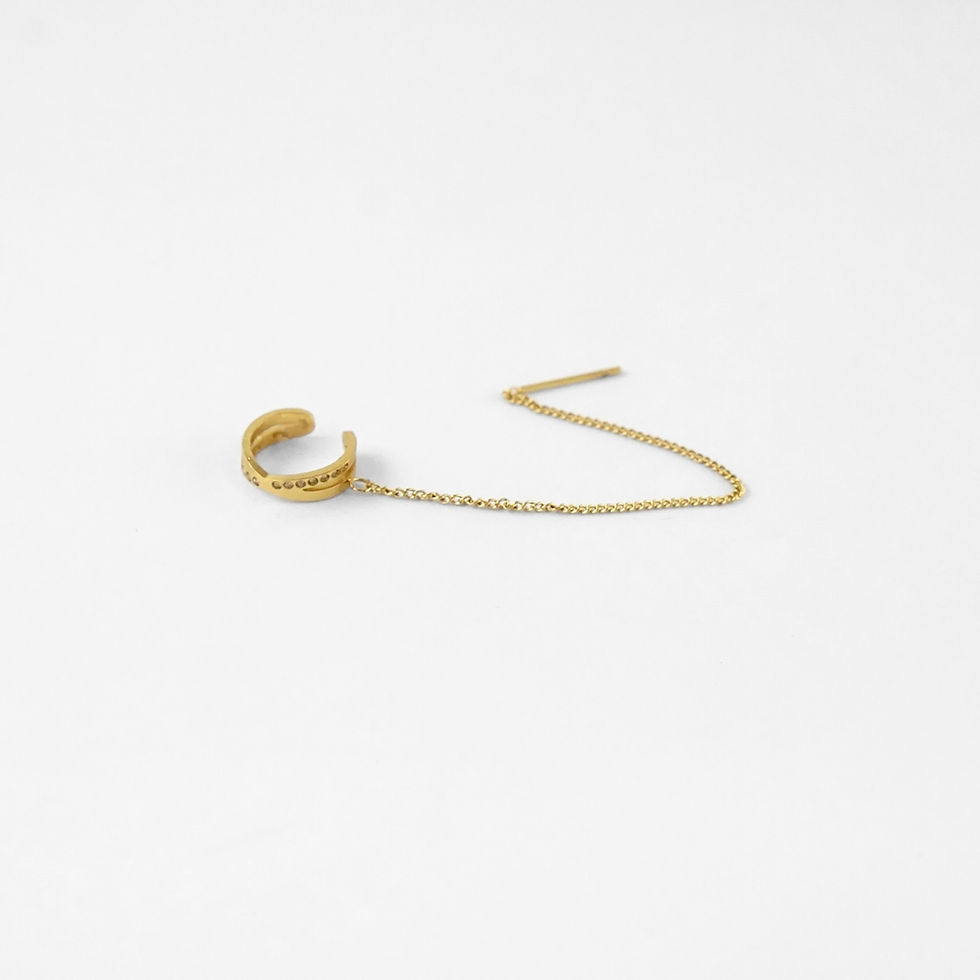 bijou d’oreille au style affirmé, composé d’un ear cuff relié par une fine chaîne à une tige d’oreille