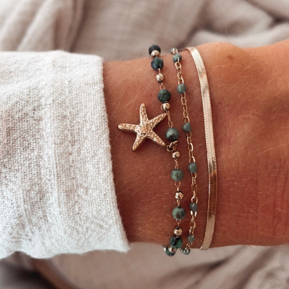 Un bracelet solaire et bohème, composé de plusieurs chaînes dorées, de perles vertes délicates et d’un pendentif étoile de me