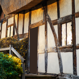 Charming traditional cottage exterior with wooden beams, small entry steps, and warm natural light — representing a fresh start, renewed Airbnb listing presentation, and the importance of first impressions in 2026.