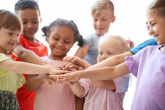 Children in a circle showing that they are a team.