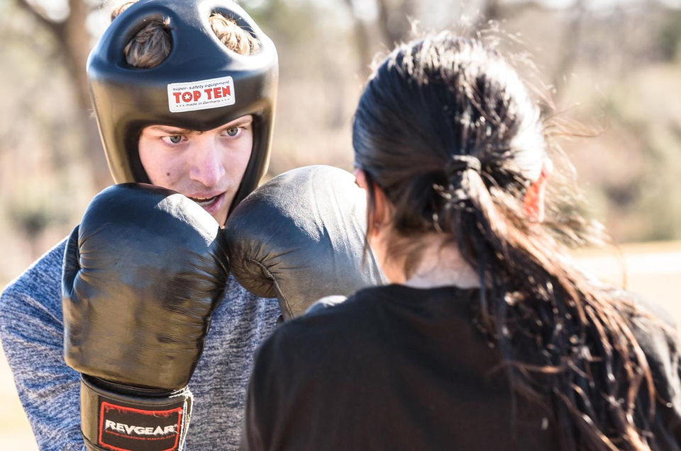 Self-defense boxing training male student with female teacher