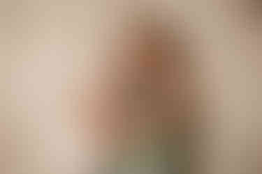 Big sister smiling and hugging newborn sister proudly