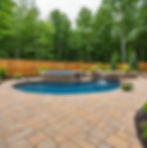 a beautiful backyard with pool and pavers all around it to a new paver stone sitting area.