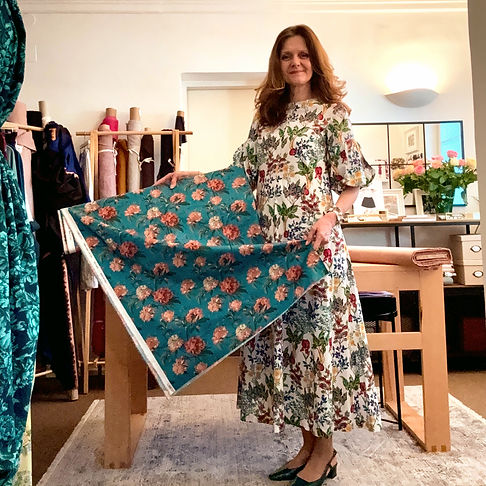 Claudia präsentiert einen türkisen Blumenstoff von Liberty in ihrem Showroom