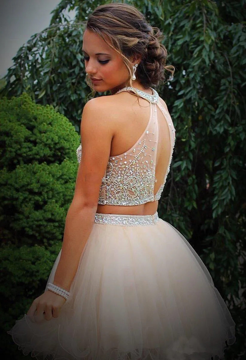 A Sweet 16 celebrant wears a beautiful peach-colored two-piece dress, standing gracefully with green trees in the background.