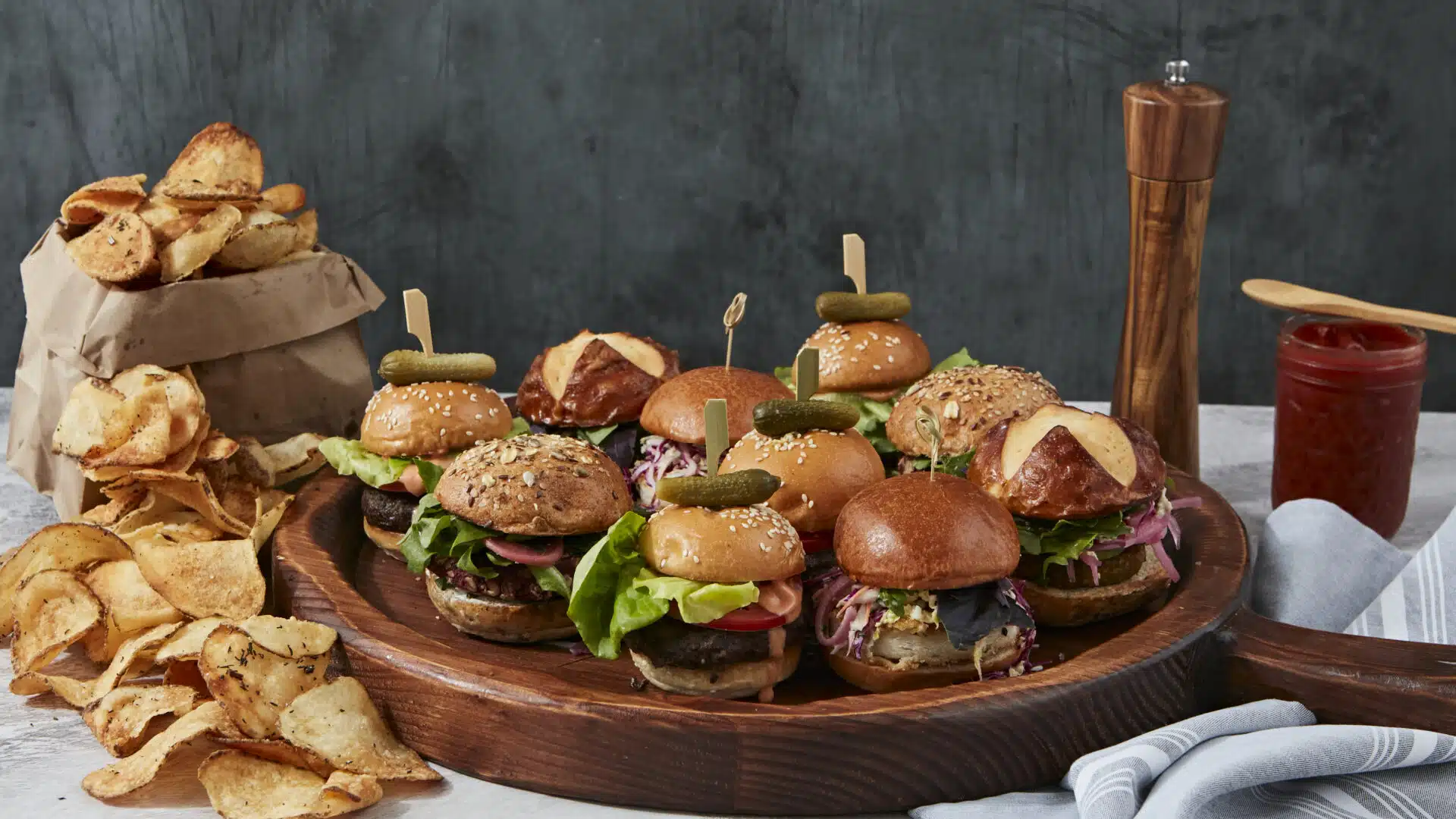 A delightful spread of crispy potato chips and a selection of mini burgers, perfect for snacking and sharing at a Bar Mitzvah celebration.