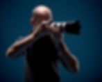 In this image, a photographer holds a camera equipped with a zoom lens, ready to capture distant subjects with precision and clarity.