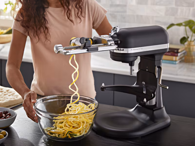 Gifts that make an impact: black and silver KitchenAid mixer with a special cutting tool attached.