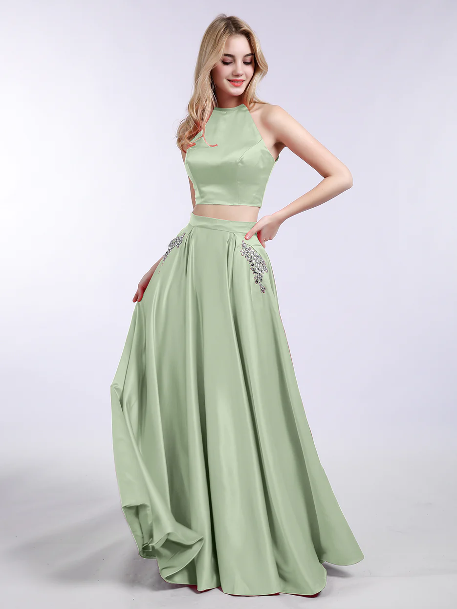 A Sweet 16 celebrant wears a stunning green two-piece dress, looking to the side with her blonde hair flowing elegantly