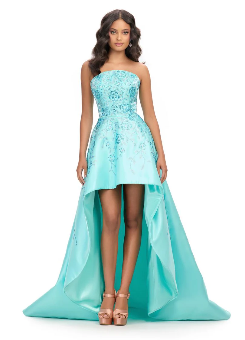 A beautiful brunette Sweet 16 celebrant wears an elegant aqua green dress, posing for a photograph in a New York City photography studio. The soft color of her dress complements the studio lighting, highlighting her graceful presence.