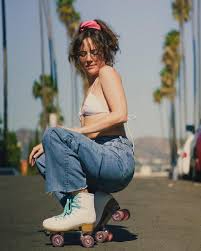 Anal Coto wearing white roller skates in a squating position