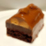 A rich layer of French chocolate ganache over nutty almond chocolate cake. Centered with creamy caramel ganache. Glazed over with French milk chocolate & toasted walnut.  Delicious to enjoy chilled or frozen.