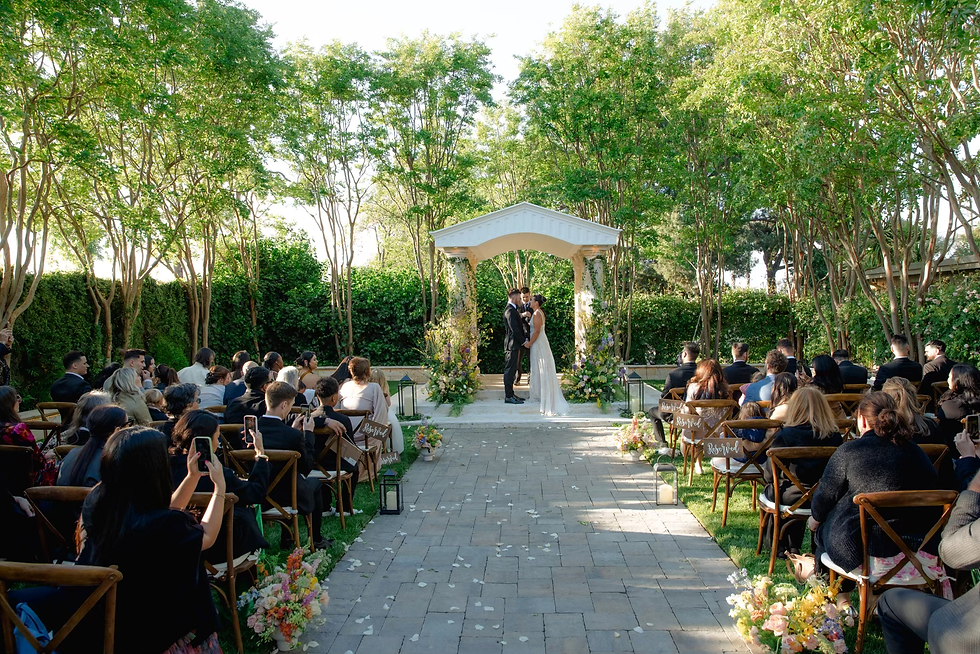 Couple Walking Down Garden Aisle Surrounded by Trees at Brownstone Gardens
