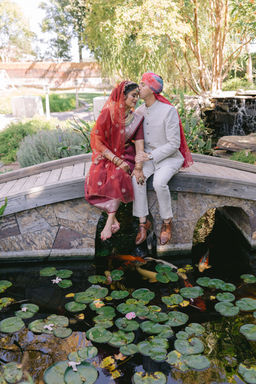 Bride and groom standing by koi pond at Brownstone Gardens, Oakley.