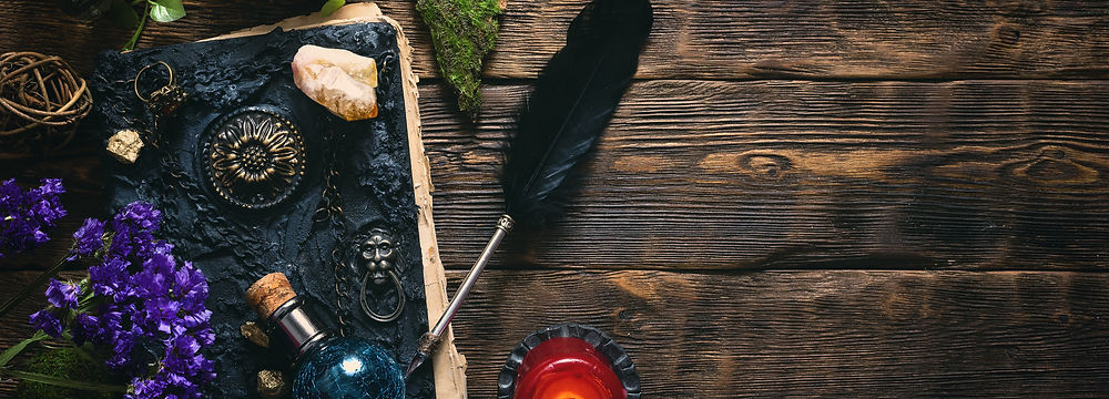 A collection of candles, bottles, and crystals against a woodgrain background