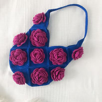 A blue crochet bag with purple roses