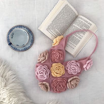 A pink crochet bag with roses
