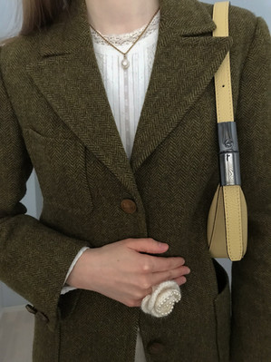 A girl wearing a green tweed blazer