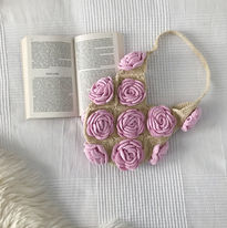 A yellow crochet bag with pink roses