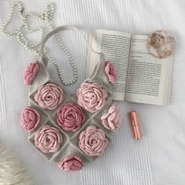 A grey crochet bag with pink roses