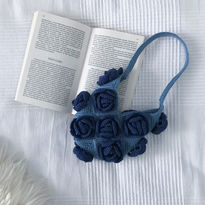 A blue crochet bag with navy roses