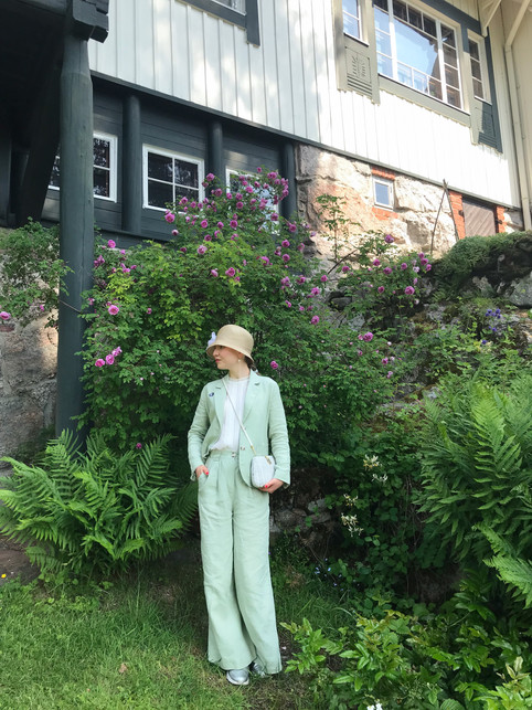 A girl in a green linen suit and summer hat