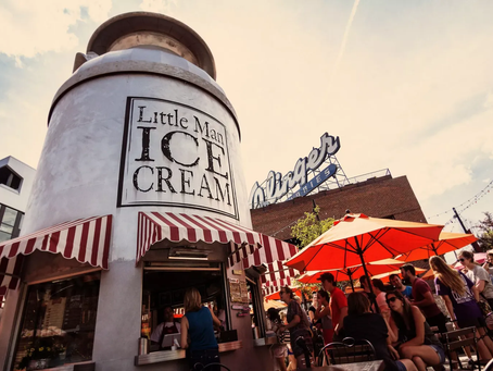 A large metal milk can with the words "Little Man Ice Cream" on it, and with an ice cream shop inside it.