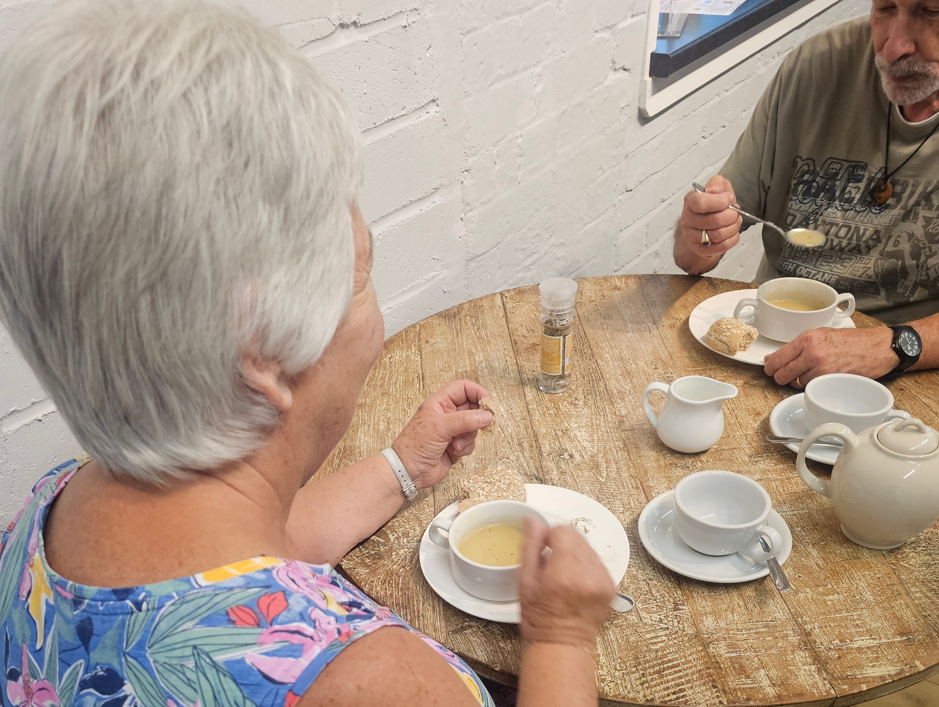 Eye-level view of volunteers serving homemade soup to guests at a friendly community lunch.