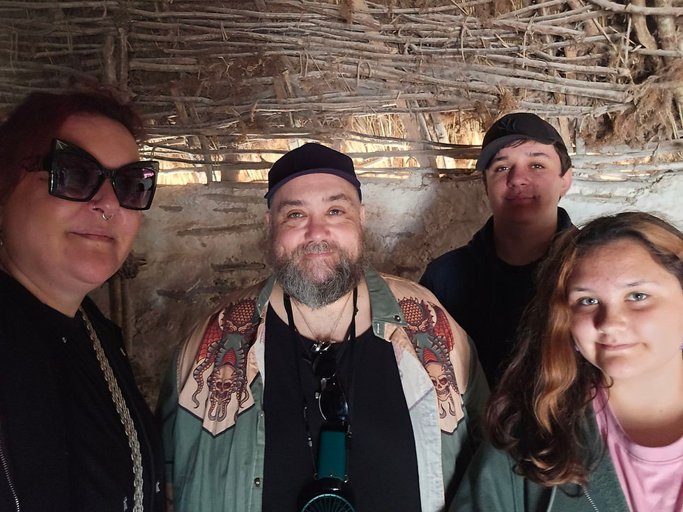 A selfie of lise, bob and their children inside one of the reconstructed neolithic houses.