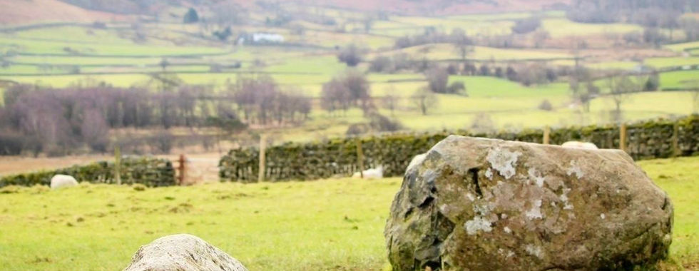 Large standing stones at Castlerigg Stone Circle with hills.
