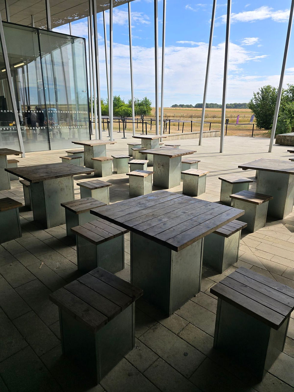 The seating outside the cafe. Each square table has 3 or 4 seats around it.
