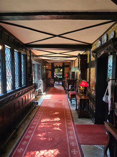 Long corridor at Speke Hall with red carpet and timber beams.