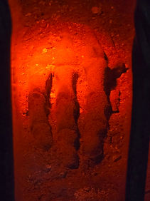 A close up of the mummified hand inside the pub. The hand is orange due to the light.