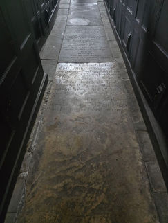 a grave slab on the floor of the church. It is well worn.