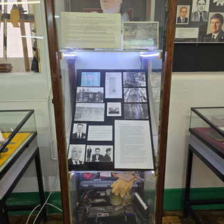 Museum display case with historic police records and photos.