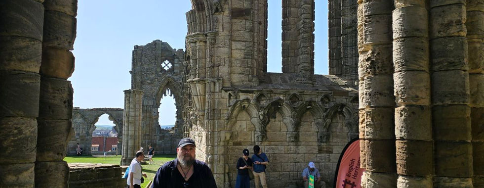 Bob using his rollator on a ramp at Whitby Abbey ruins.