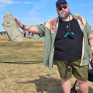Bob pretending to push over one of the leaning stones of stonehenge but it is just an optical illusion.
